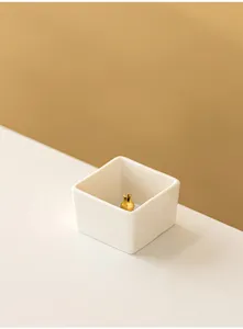 Minimalist square ceramic incense holder with gold insert, elegant modern home decor detail shot.