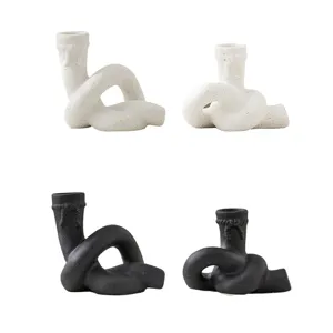Gros plan de bougeoirs en céramique au design de nœud créatif en noir et blanc pour la décoration.