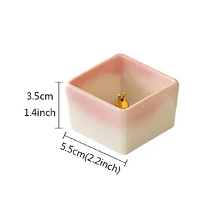 Minimalist square ceramic incense holder with pink white gradient and brass pin stand detail.