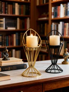 Detailed view of modern minimalist geometric metal candle holders with lit pillar candles.