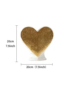 Detail view of the elegant heart-shaped ceramic vase with golden textured surface and white base.