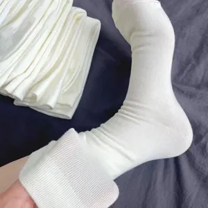 Detailed view of white knitted slouch socks for women, showing soft ribbed texture and elastic fit.