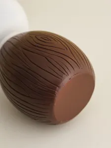 Vista de cerca detallada del cuerpo del quemador de incienso de madera marrón y tapa blanca.