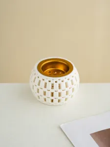 Close-up detail of a white ceramic 3D printed incense burner featuring an elegant gold inner bowl.