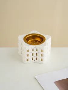 Close up view of a minimalist 3D printed star incense burner with gold metal tray interior.