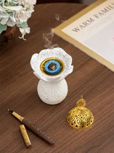 Gros plan de brûleur d'encens en résine avec base de fleur blanche et fumée délicate.