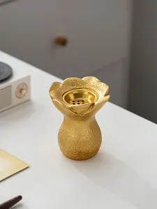Gros plan détaillé d'un brûleur d'encens en résine dorée en forme de fleur pour décoration.