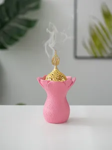Encensoir en resine du Moyen-Orient avec dôme creux doré et base de fleurs roses.
