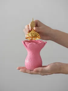 Brûleur d'encens en résine du Moyen-Orient tenu à la main avec un couvercle doré.