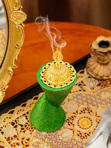 Detailed close-up view of a resin incense burner, Arabic double-cone style with gold ornate lid.