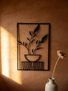 Detailed close-up of modern black metal wall art featuring minimalist botanical design.