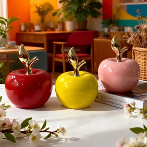 Vista dettagliata di ornamenti di mele in ceramica colorata con steli dorati per decorare.