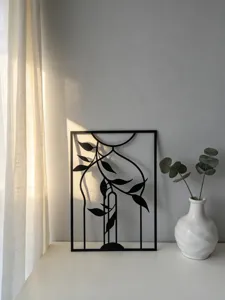 Close up of abstract black metal wall art piece with leaf design, minimalist modern home decor.