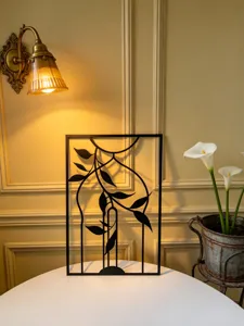 Metal wall art detail showcasing elegant botanical leaf design in a chic vintage interior setting.