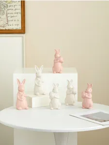 Ceramic easter rabbit figurines set detail showing cute pink and white bow tie bunny holding eggs.
