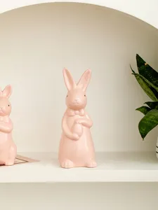 Pink ceramic rabbit figurine with bow and egg for Easter home and desk decor ornament