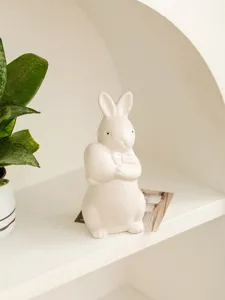 Ceramic rabbit detail showing cute bow tie and holding egg design for home shelf decor.
