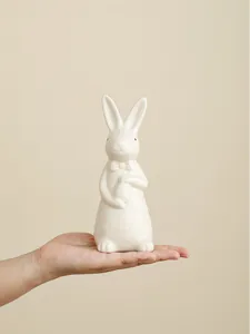 White ceramic Easter bunny figurine with bow tie and egg, cute desktop home decor craft ornament.