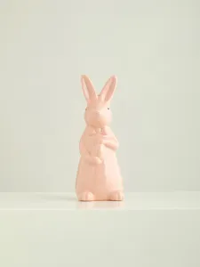 Pink ceramic Easter bunny figurine with bow tie and egg, cute desktop decor detail view.