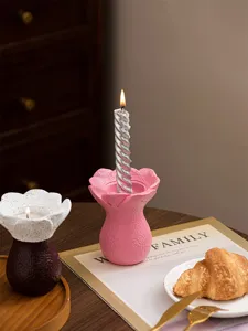 Detail view of minimalist resin flower candle holder and scented candle on desktop decor.