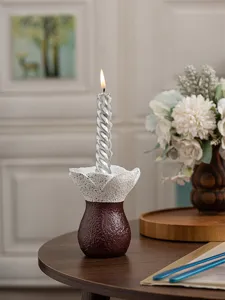Detailed shot of a minimalist resin candle holder with flower design and silver twisted candle.