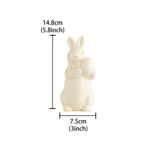 Ceramic Easter rabbit figurine holding egg detail, cute desktop decor ornament white finish.