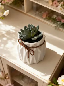Gros plan d'une succulente artificielle dans un pot en céramique blanche avec corde.