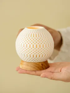 Hollow ceramic candle holder detail view, exquisite 3d printed mesh design with wood base.