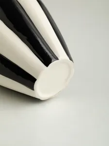 Detail close-up of Nordic minimalist black white striped ceramic vase for home decor.