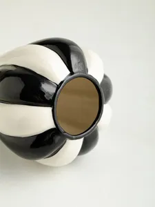 Close-up detail of black and white striped ceramic vase, glossy finish, modern tabletop decor