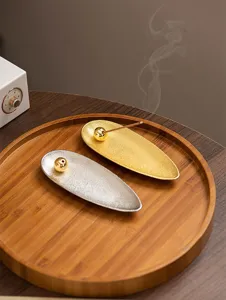 Detailed close-up of modern creative willow leaf incense holder set with golden and silver finish.