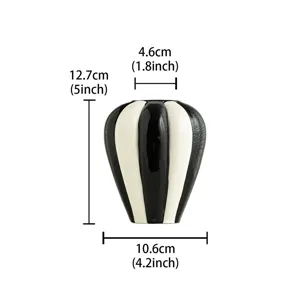 Nordic minimalist black and white ceramic vase detail shot showing smooth striped surface.