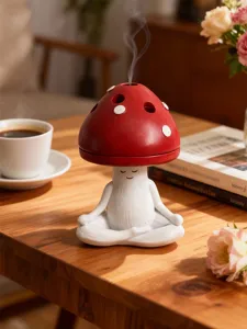 Detailed close-up of the cute meditating mushroom incense burner on a warm cozy wooden tabletop.