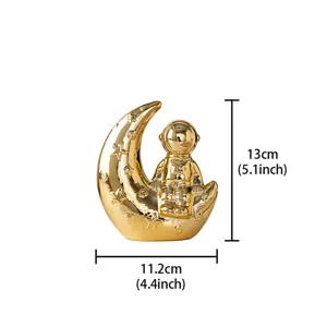 Gold ceramic astronaut moon ornament detail view showing dimensions for home decor shelf.