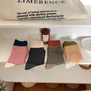 Detail view of women's color-block ribbed striped mid-calf socks in assorted cozy colors.