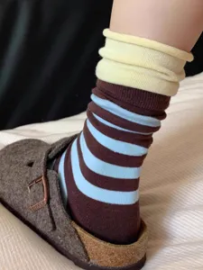 Detail shot of color-blocked striped slouch socks with rolled cuffs, Japanese style.