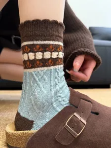 Close-up detail of vintage style wool knit socks with floral patterns and cozy winter warmth.