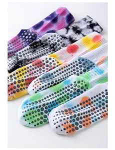 Close-up view of colorful tie-dye yoga socks with non-slip grip dots for indoor fitness.