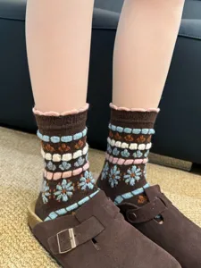 Cozy vintage style wool knit socks with cute floral pattern and ruffle trim, detail shot.