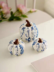 Detail view of blue and white ceramic pumpkin ornaments, floral pattern decor for home table.