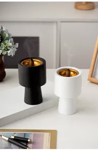Modern minimalist incense burner with golden inner bowl, elegant home decor fragrance diffuser detail.