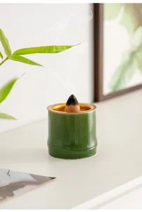 Dettaglio in primo piano del bruciatore d'incenso in ceramica verde a forma di bambù sulla scrivania.