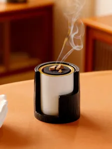 Detailed shot of modern Middle Eastern aromatherapy incense burner with wood texture and ceramic cup.