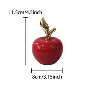 Vista dettagliata della mela decorativa in ceramica rossa con stelo dorato e finitura lucida.