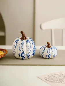 Ceramic pumpkin figurine detail, blue and white floral pattern, elegant home tabletop decor.
