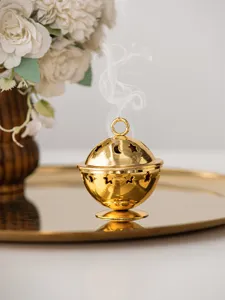 Golden mini metal incense burner with star and moon cutouts for elegant tabletop decor.
