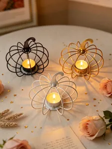 Detail view of metal pumpkin tea light candle holders set in black, gold, and white.