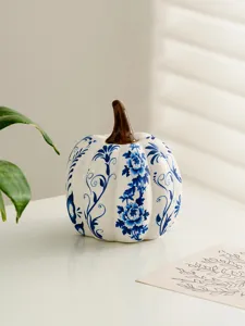 Blue and white ceramic pumpkin decor detail, elegant floral pattern, tabletop ornament.