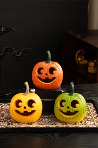 Halloween resin pumpkin ornament detail shot featuring carved facial expressions and bright colors.