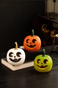 Resin Halloween pumpkin detail showing carved smiling faces in white, orange and green.